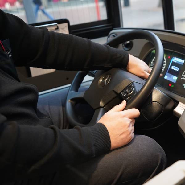 Ein Busfahrer sitzt am Steuer eines Busses.