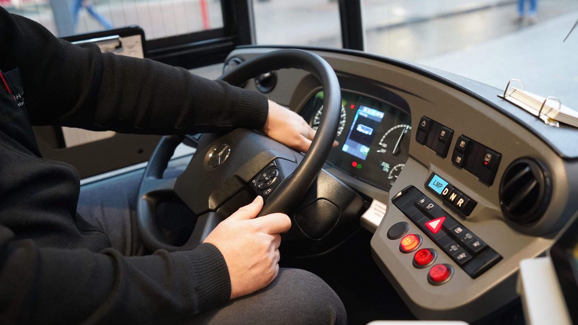 Ein Busfahrer sitzt am Steuer eines Busses.