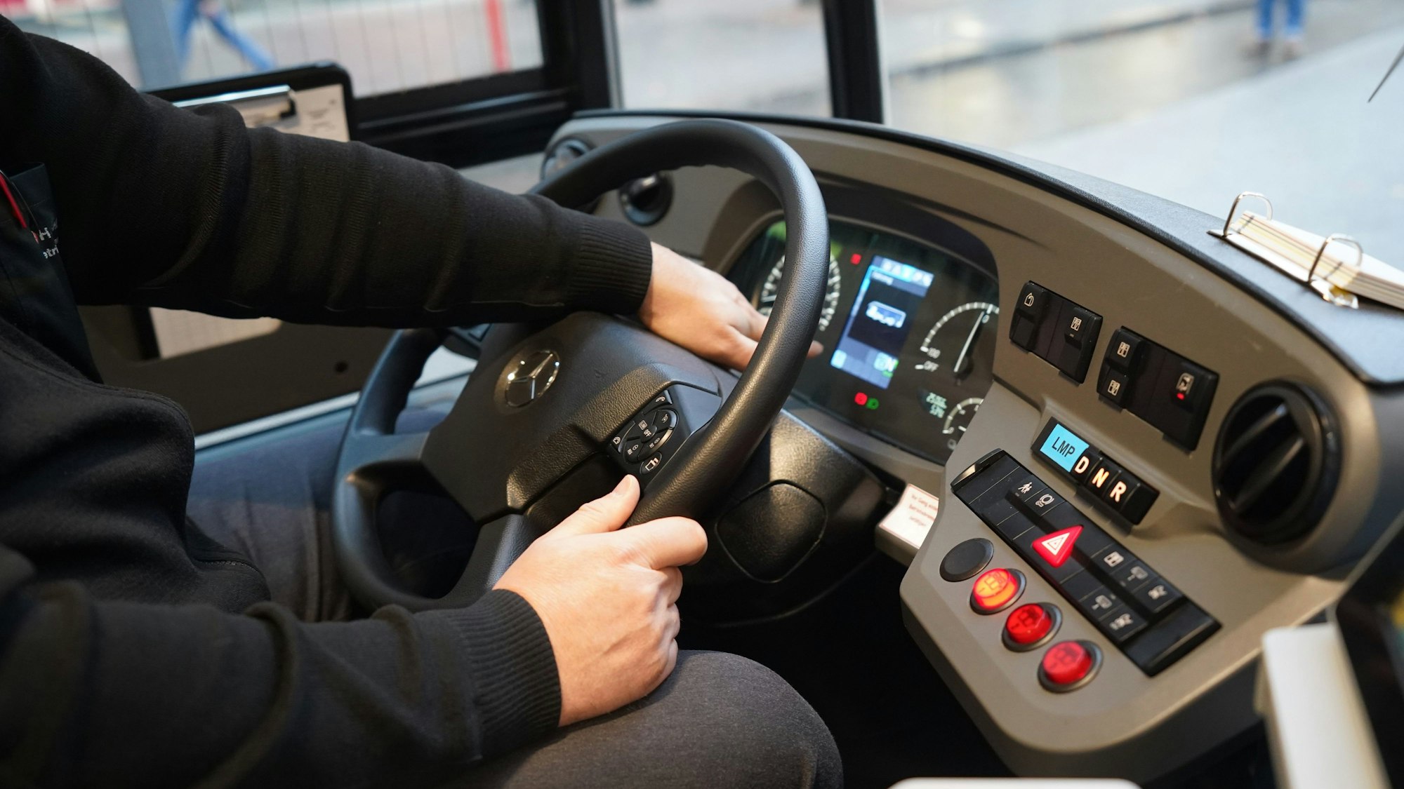 Ein Busfahrer sitzt am Steuer eines Busses.