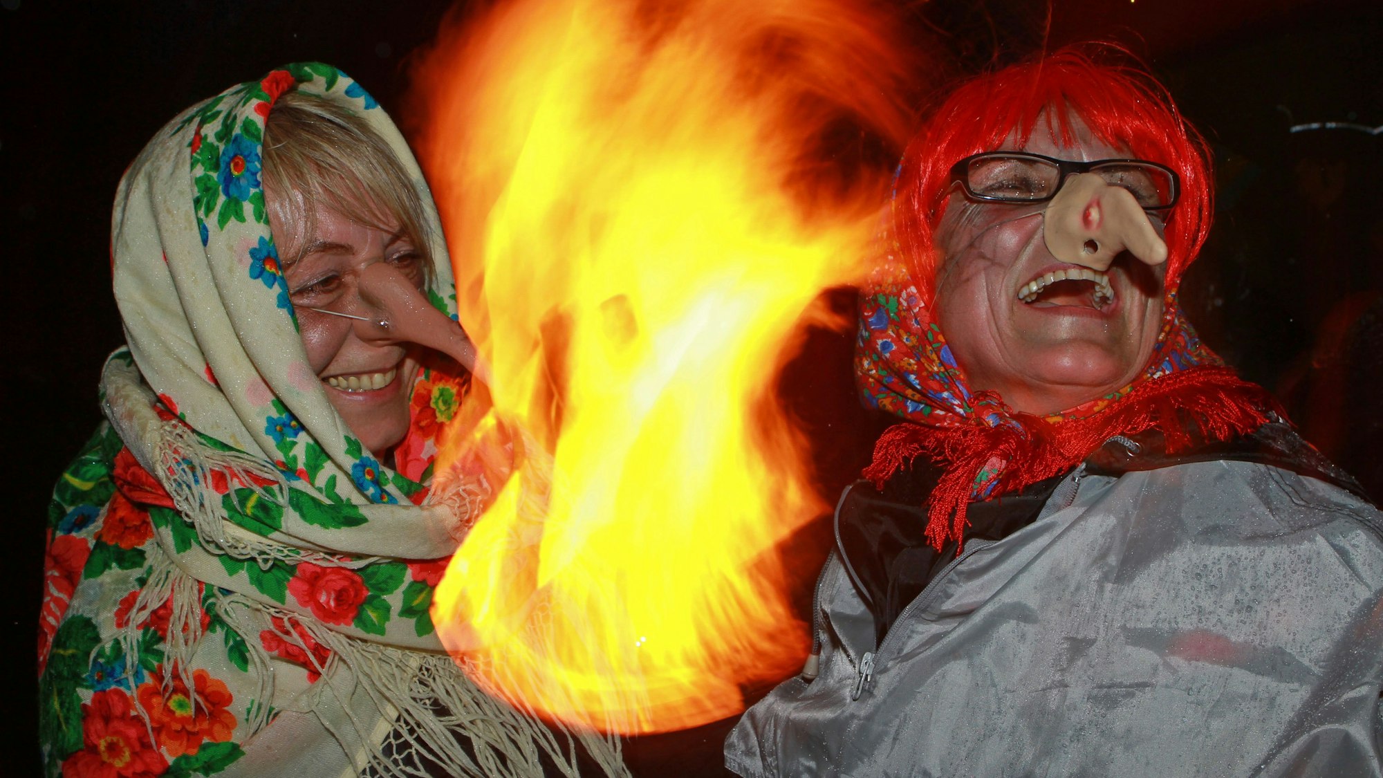 In Hexen- und Teufelskostümen feiern Menschen die Walpurgisnacht.