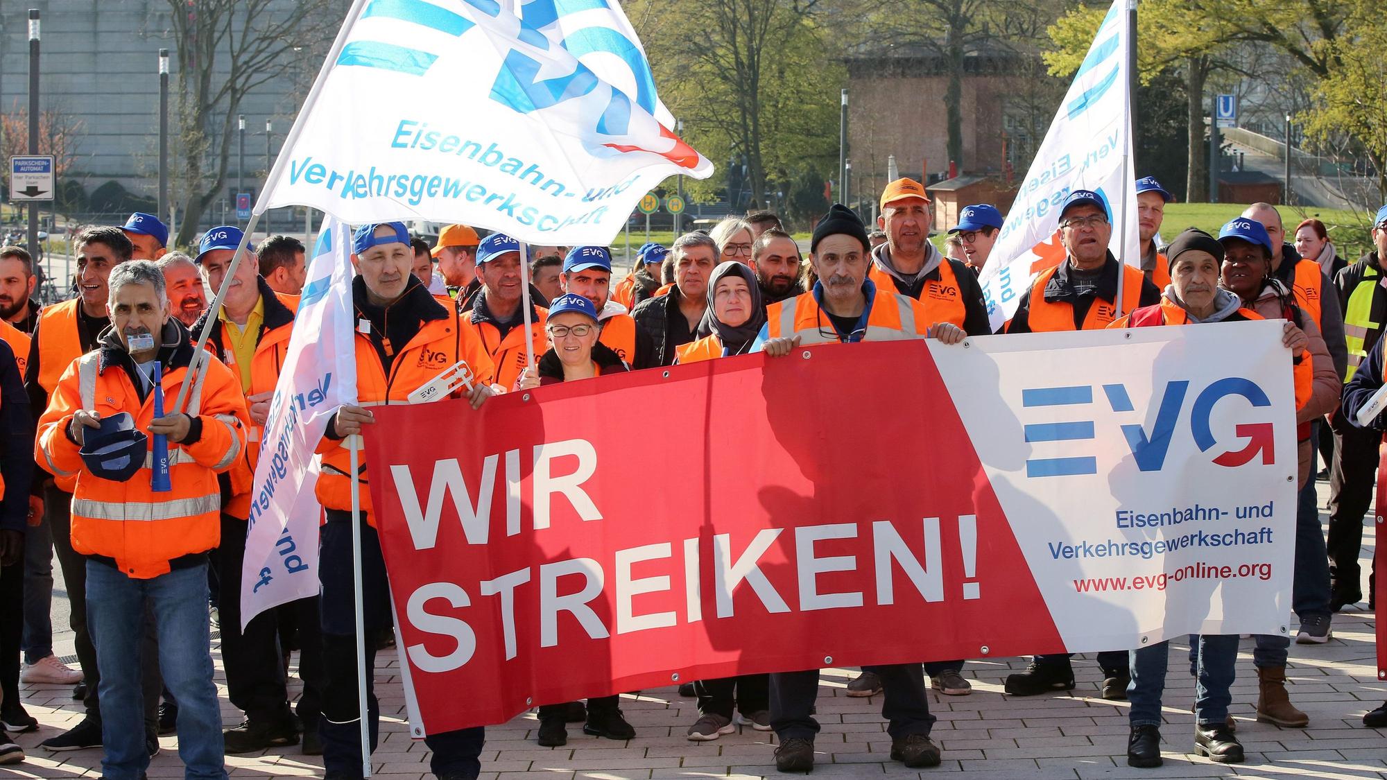 ARCHIV - 21.04.2023, Hamburg: Warnstreikende der Eisenbahn- und Verkehrsgewerkschaft EVG stehen bei einer Kundgebung vor dem Bahnhof Dammtor zusammen.