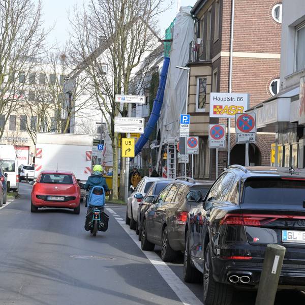 Ein Auto und ein Motorrad fahren auf der unteren Hauptstraße in Bergisch Gladbach.