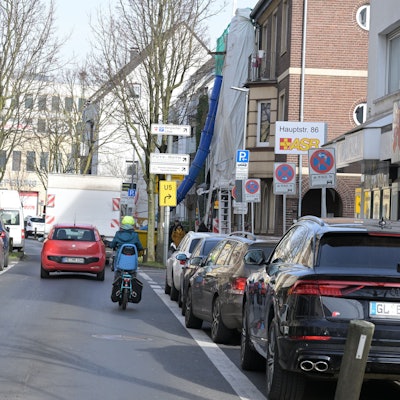 Ein Auto und ein Motorrad fahren auf der unteren Hauptstraße in Bergisch Gladbach.
