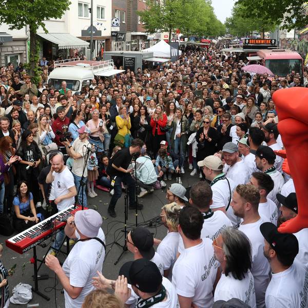 Ein Chor singt auf der voll gefüllten Venloer Straße.