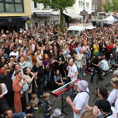 Ein Chor singt auf der voll gefüllten Venloer Straße.