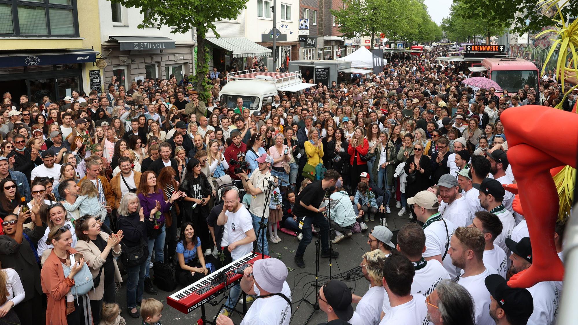 Ein Chor singt auf der voll gefüllten Venloer Straße.
