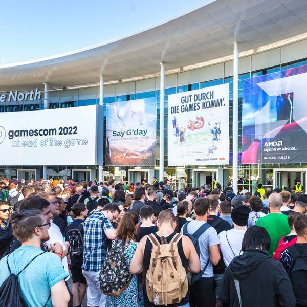 Mehrere Besucher der Gamescom stehen am Haupteingang der Messe.
