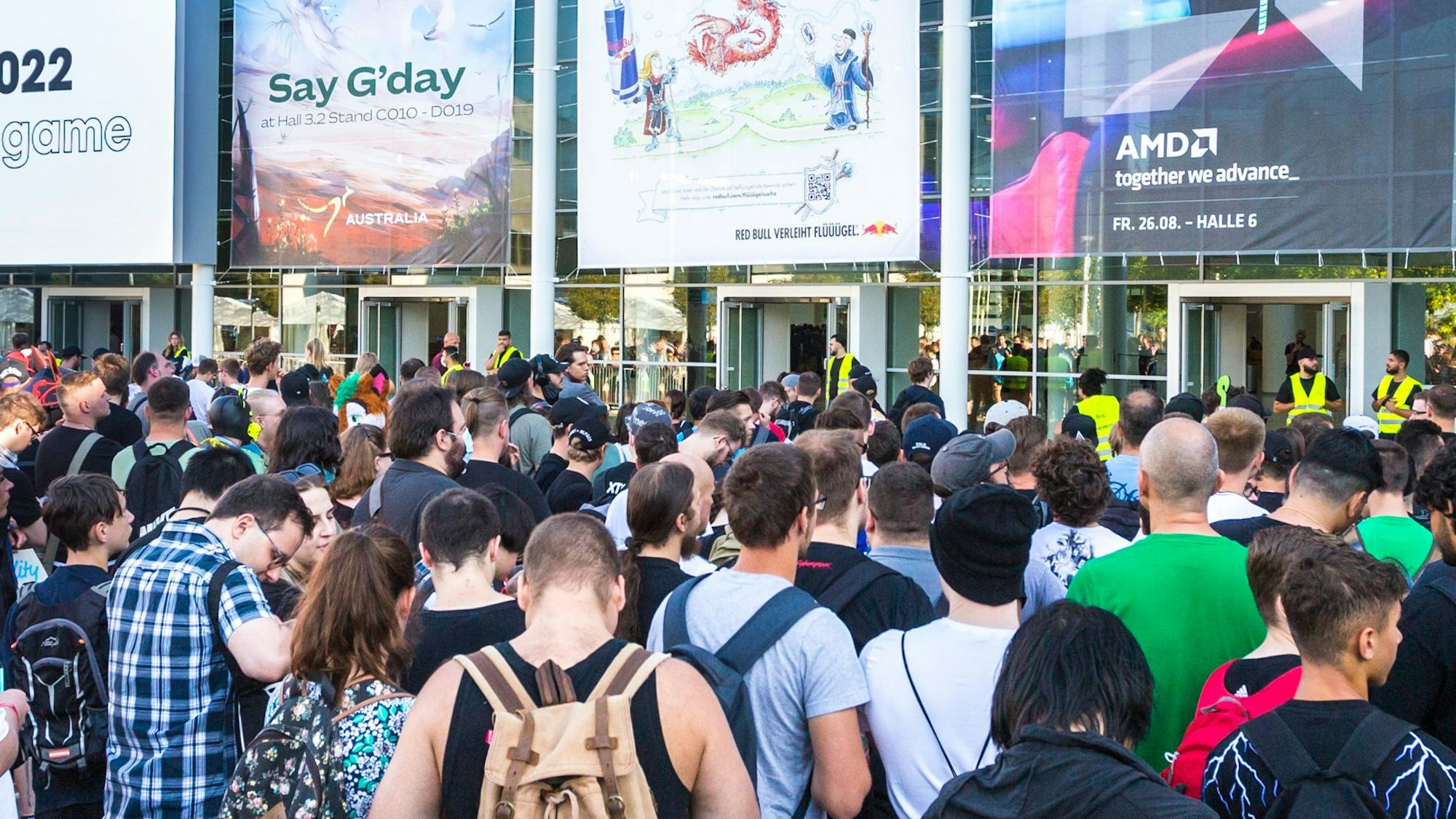 Mehrere Besucher der Gamescom stehen am Haupteingang der Messe.