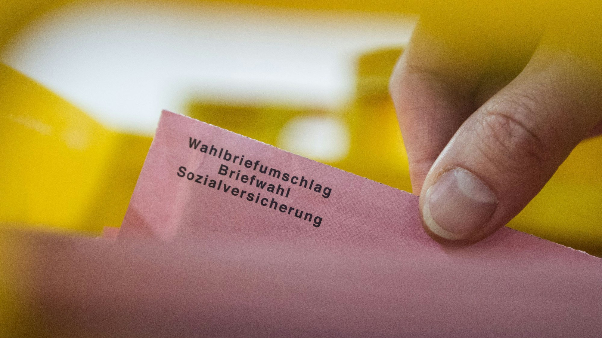 Ein Besucher eines Presserundgangs zieht in einer Lagerhalle in Berlin einen Wahlbrief aus einer Kiste.