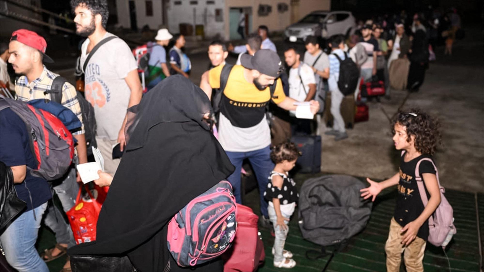 Menschen warten in der Schlange vor einer Passagierfähre in Port, um evakuiert zu werden.