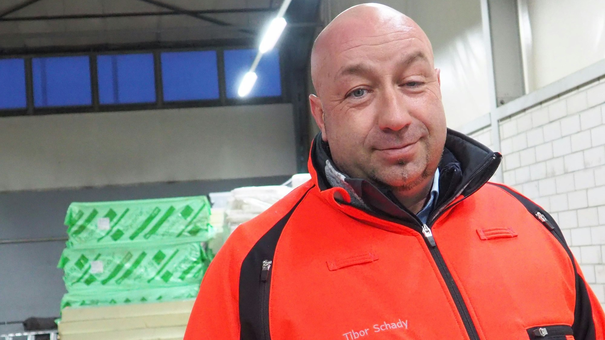 Das Bild zeigt einen Mann in signalroter Jacke.