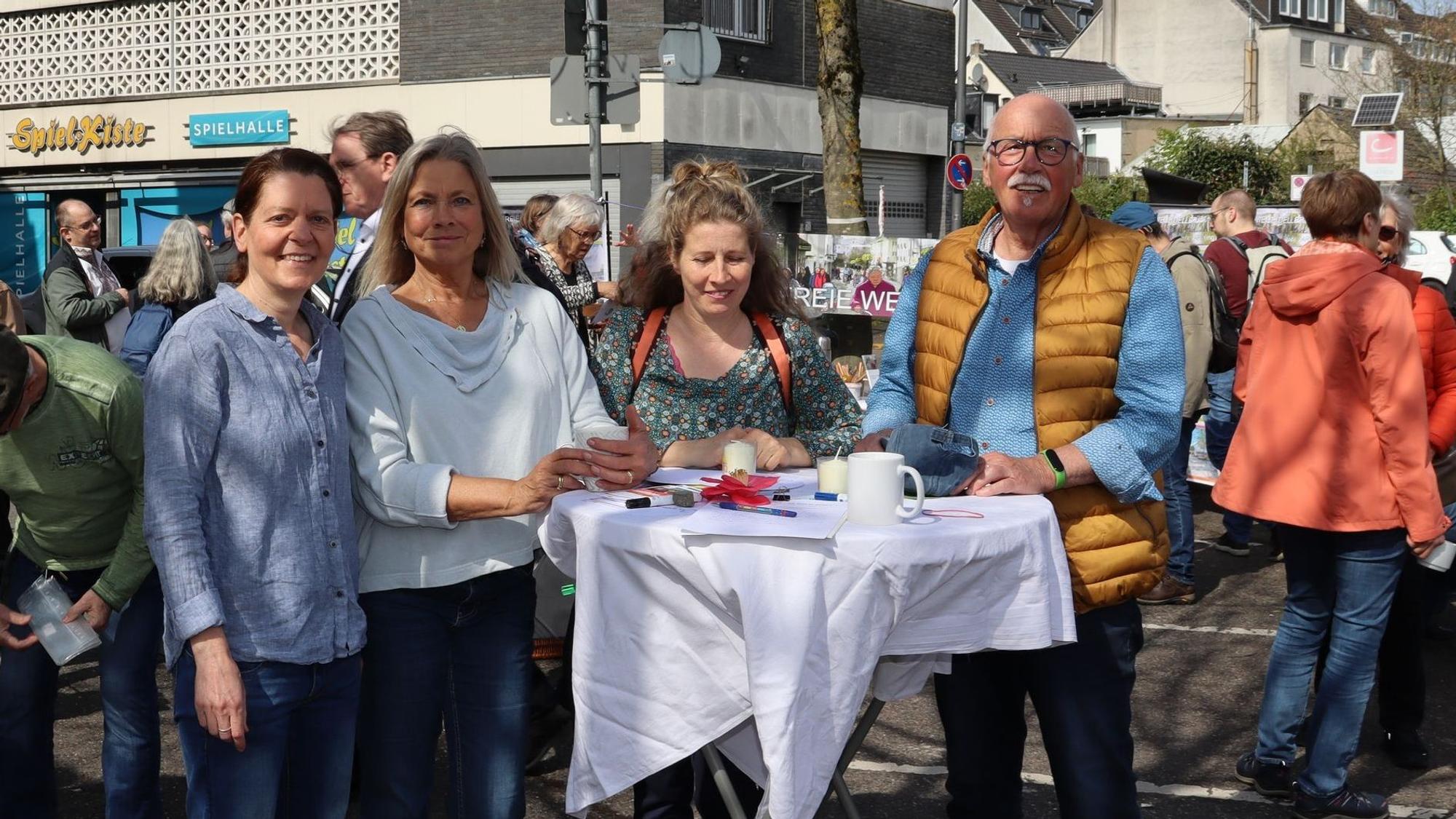 Menschen stehen um einen Tisch in der Fußgängerzone