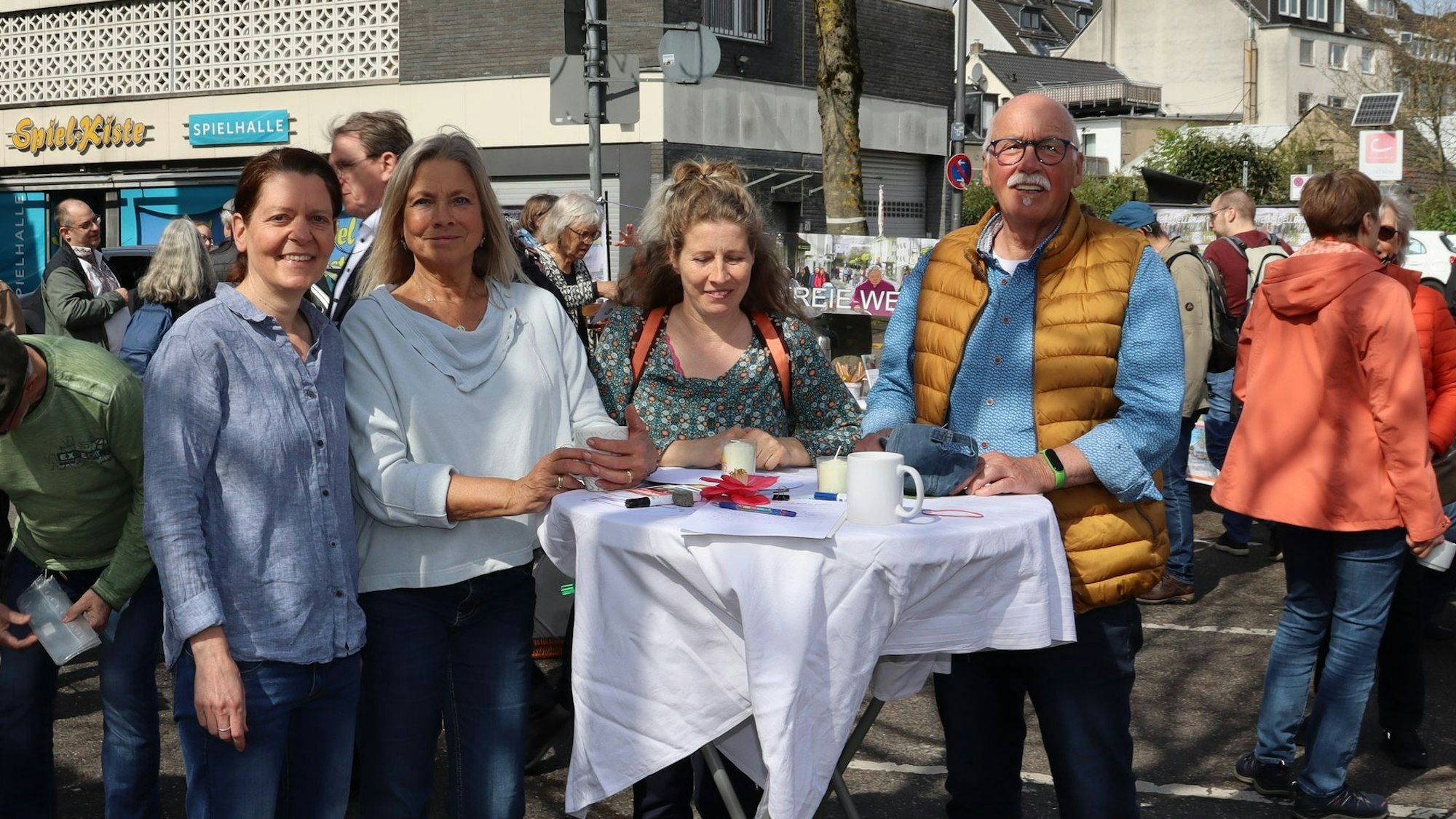 Menschen stehen um einen Tisch in der Fußgängerzone