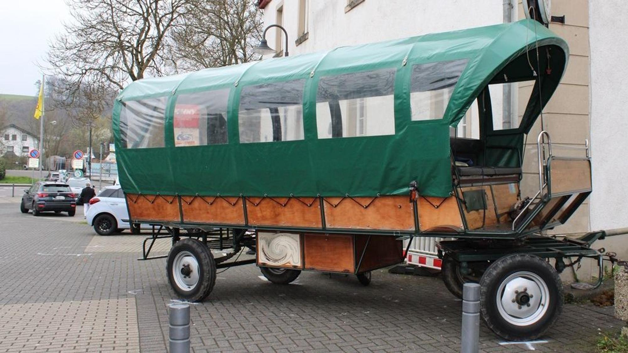 Ein Planwagen steht verkeilt an einer Hauswand.