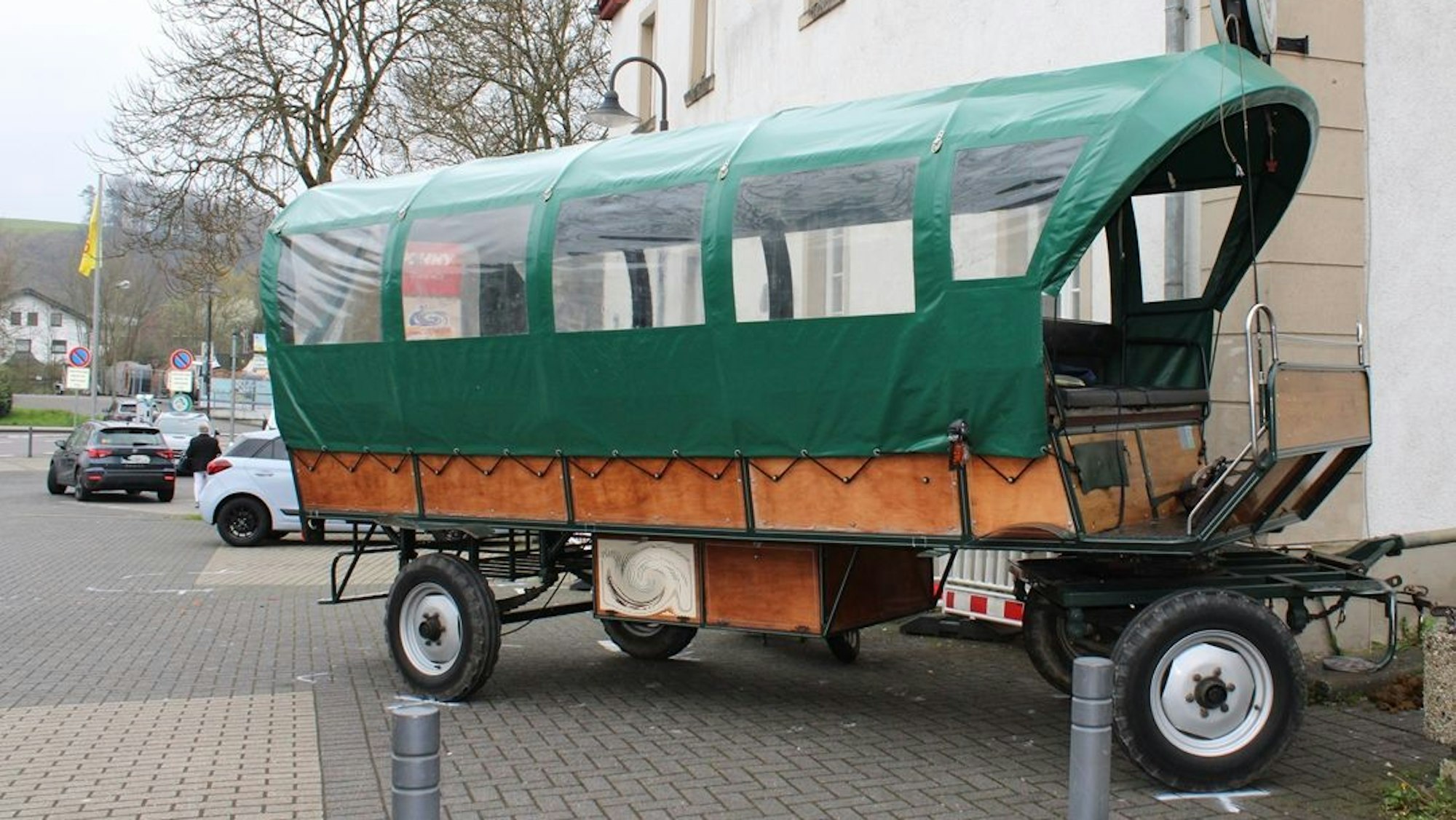 Ein Planwagen steht verkeilt an einer Hauswand.