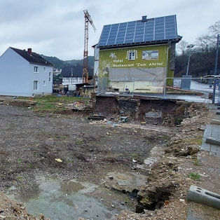 Unterschiedliche Geschwindigkeiten in der gleichen Gasse: Einerseits begonnener Wiederaufbau, daneben oder gegenüber immer noch Ruinen.
