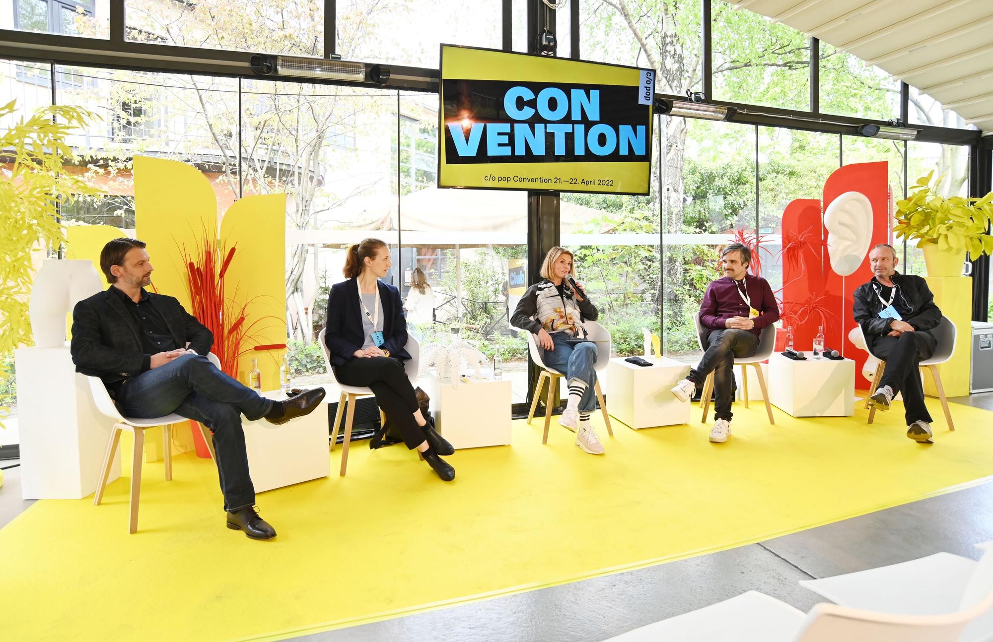Mehrere Teilnehmer sitzen bei einer Podiumsdiskussion auf der Bühne.