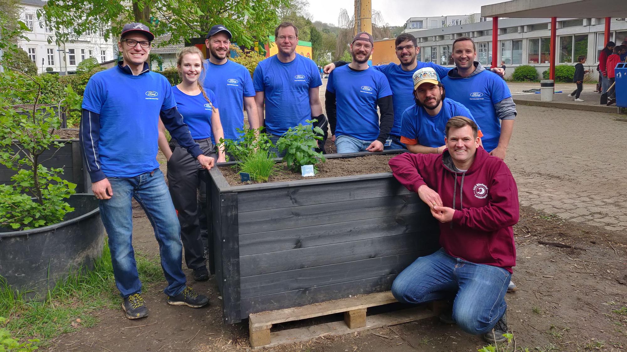 Das achtköpfige Ford-Team mit Sebastian Lemmer an einem der zehn neuen Hochbeete der GGS Büscherhof.