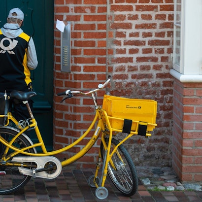 Ein Postbote verteilt Briefe in der historischen Innenstadt von Lüneburg.