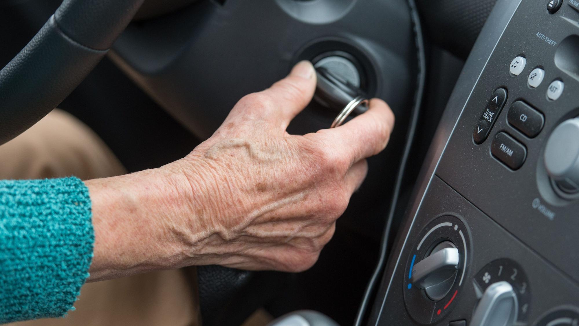 Eine Rentnerin startet mit dem Zündschlüssel ihr Auto.