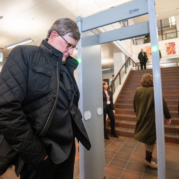 Kardinal Rainer Maria Woelki wartet im Foyer des Landgerichts vor der Sicherheitsschleuse.