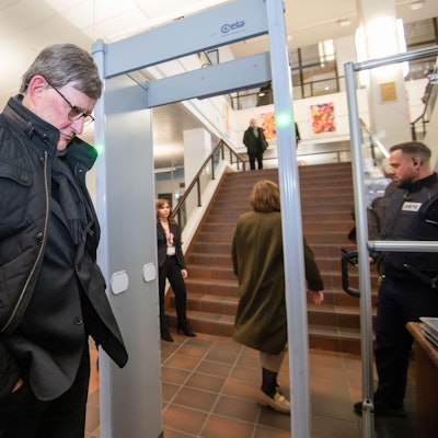 Kardinal Rainer Maria Woelki wartet im Foyer des Landgerichts vor der Sicherheitsschleuse.