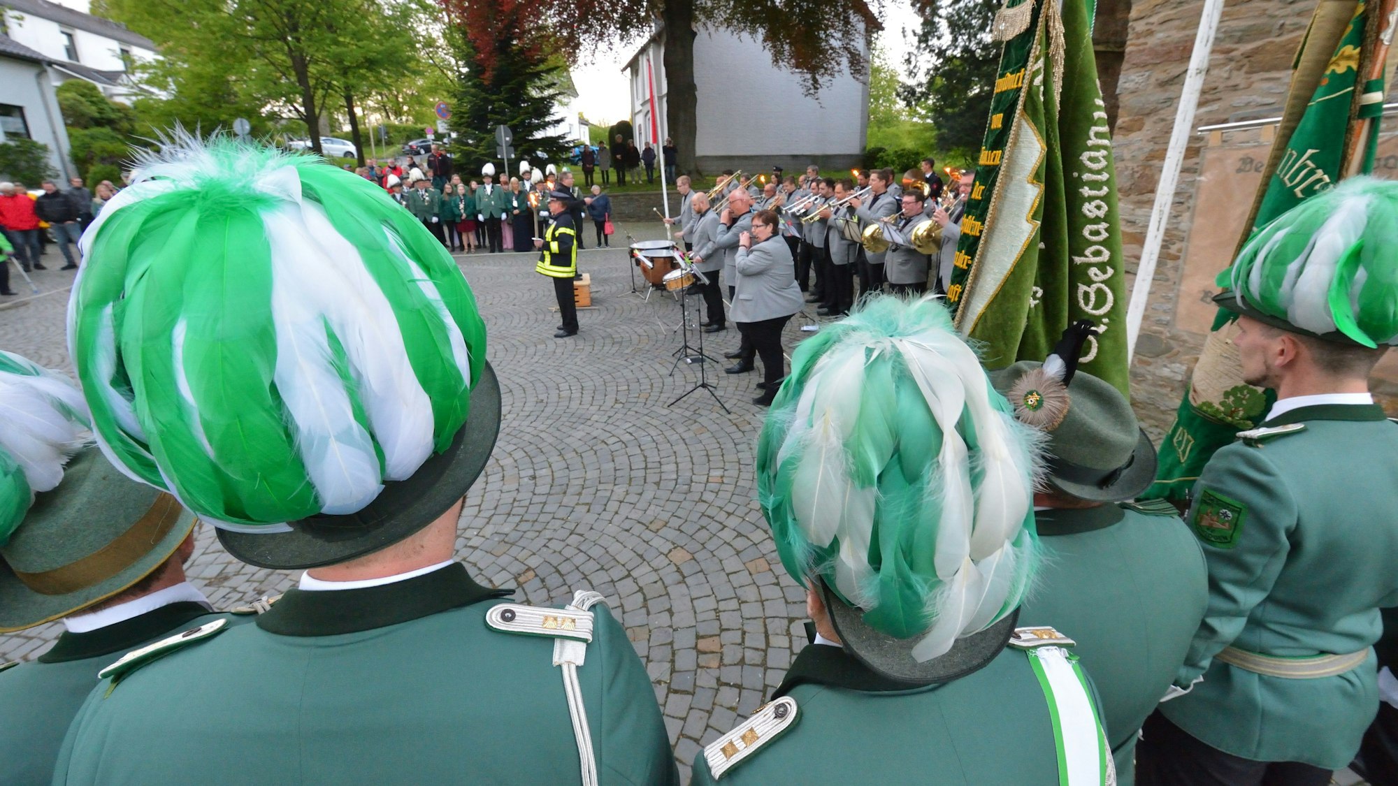 Schützen und das Blasorchester Dürscheid stehen vor der Kirche.