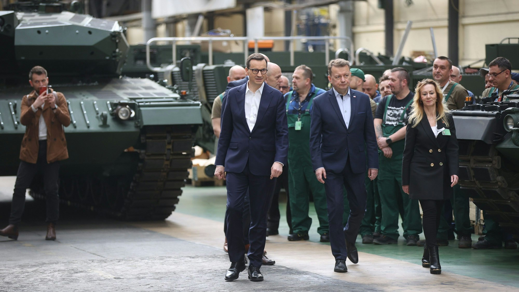 Mateusz Morawiecki, Ministerpräsident von Polen, Mariusz Blaszczak, stellvertretende Ministerpräsident und Verteidigungsminster in Polen, und Edyta Szymanska, Vorstandsvorsitzende der Mechanischen Werke Bumar-Labedy, gehen während des Besuchs bei dem Rüstungshersteller Bumar-Labedy.