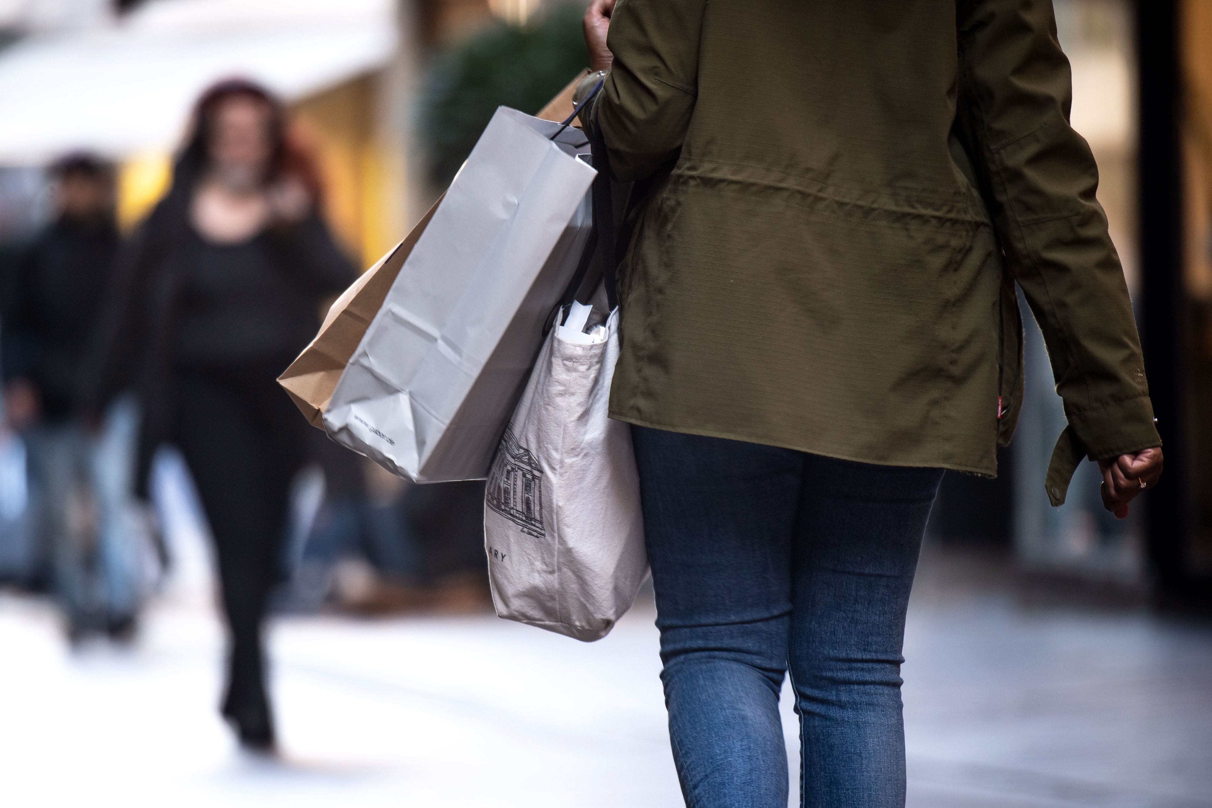 Passanten mit Einkaufstüten laufen durch die Innenstadt.