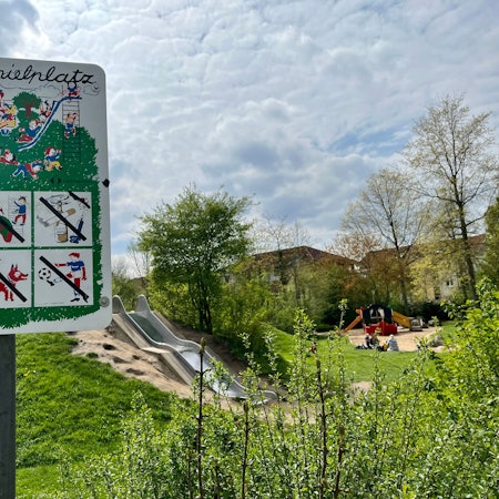 Spielplatz-Schild vor einer Rutsche