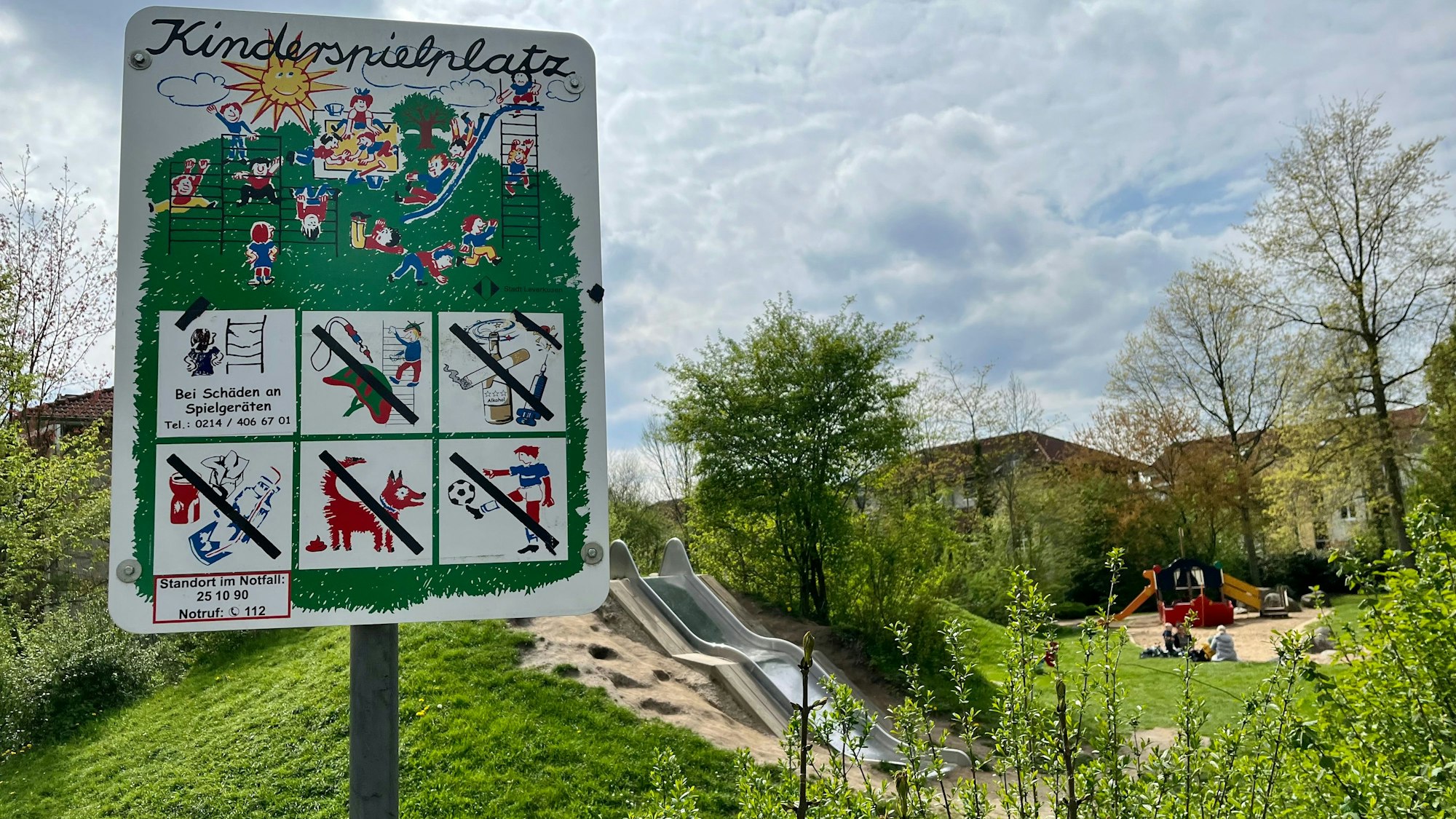 Spielplatz-Schild vor einer Rutsche