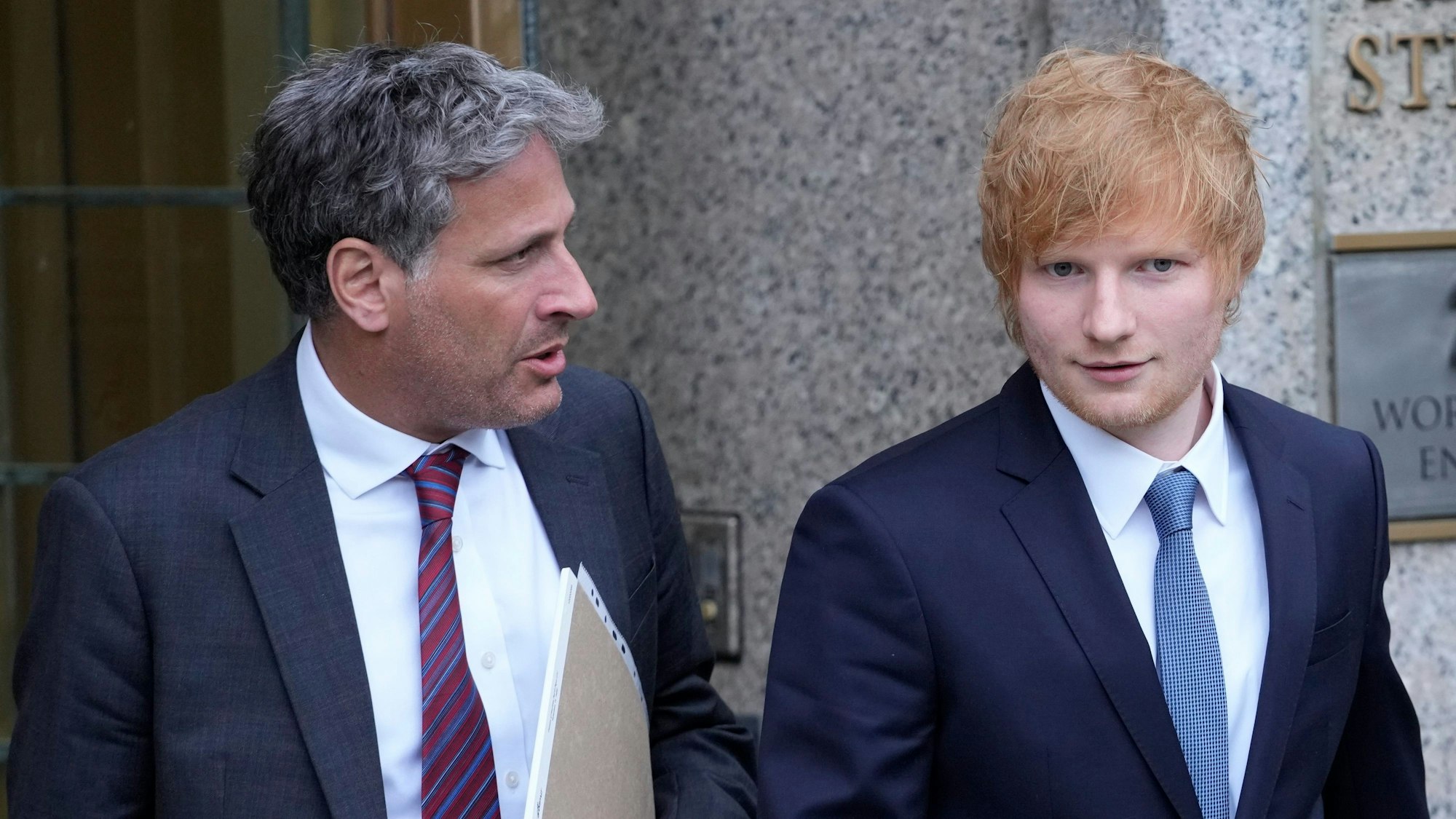 Es ist Ed Sheeran mit einer weiteren Person zu sehen, wie er das Bundesgericht verlässt.