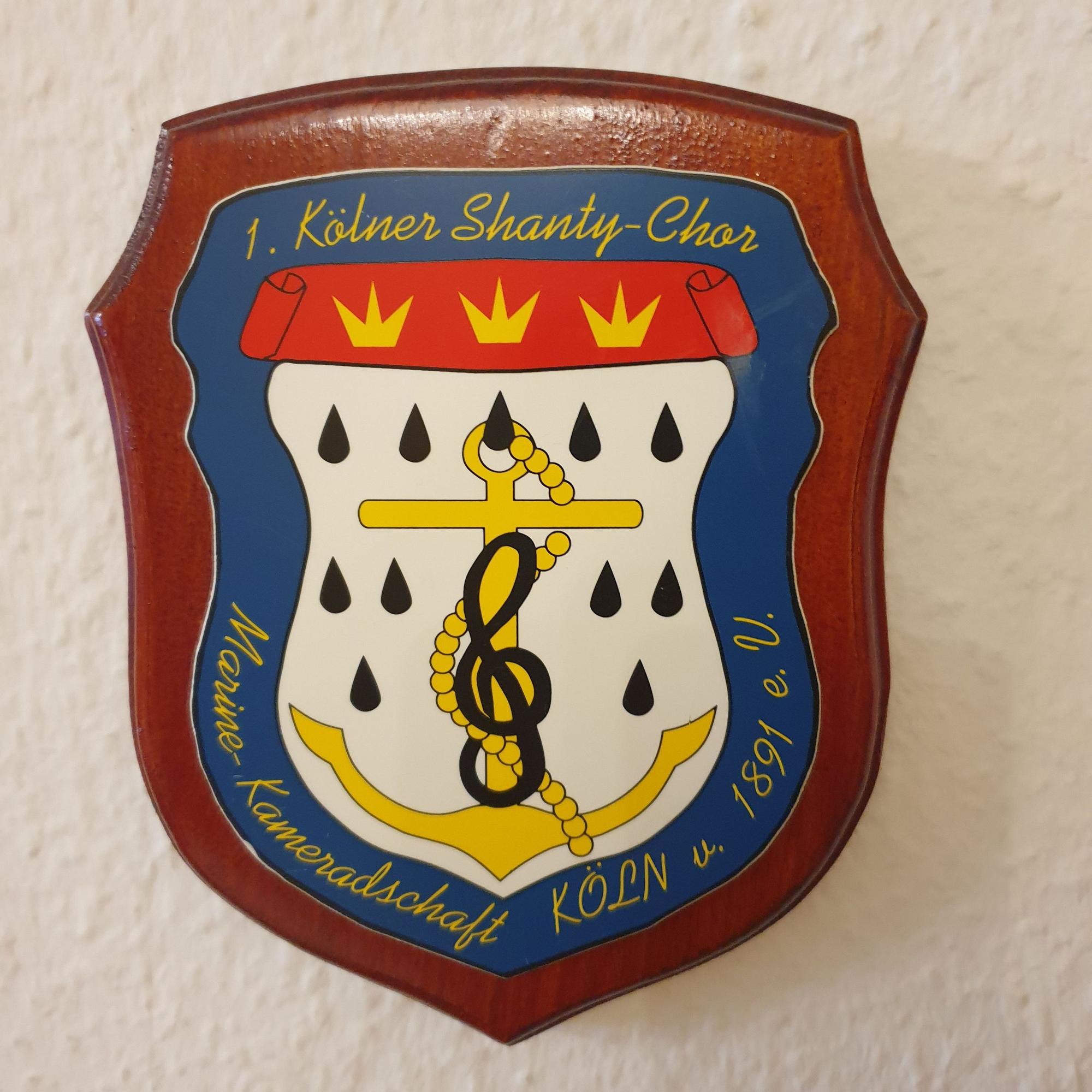 Das Emblem des Chors zeigt einen Anker mit einem Notenschlüssel.