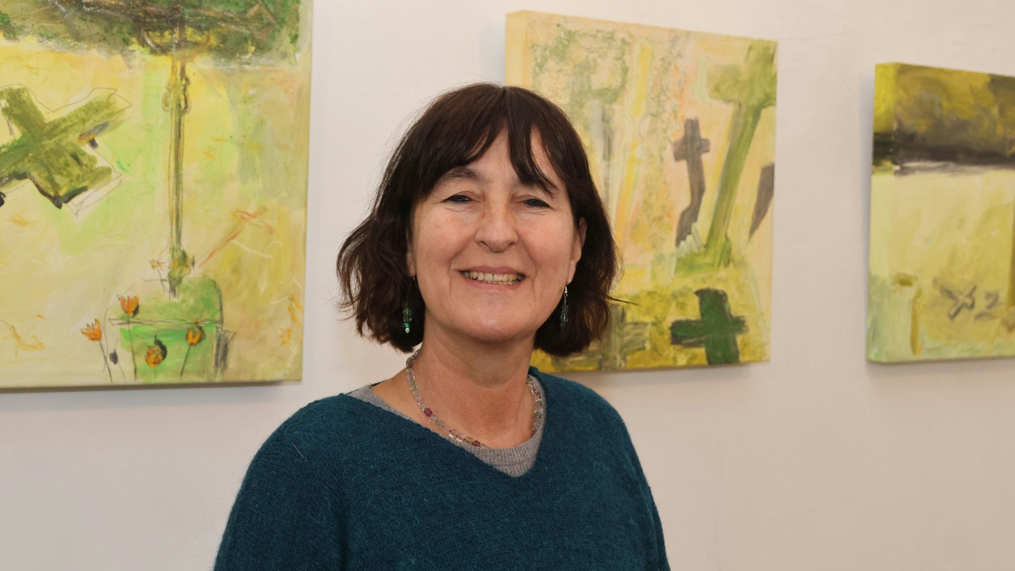 Die Reichshofer Künstlerin steht vor Bildern ihrer Ausstellung.