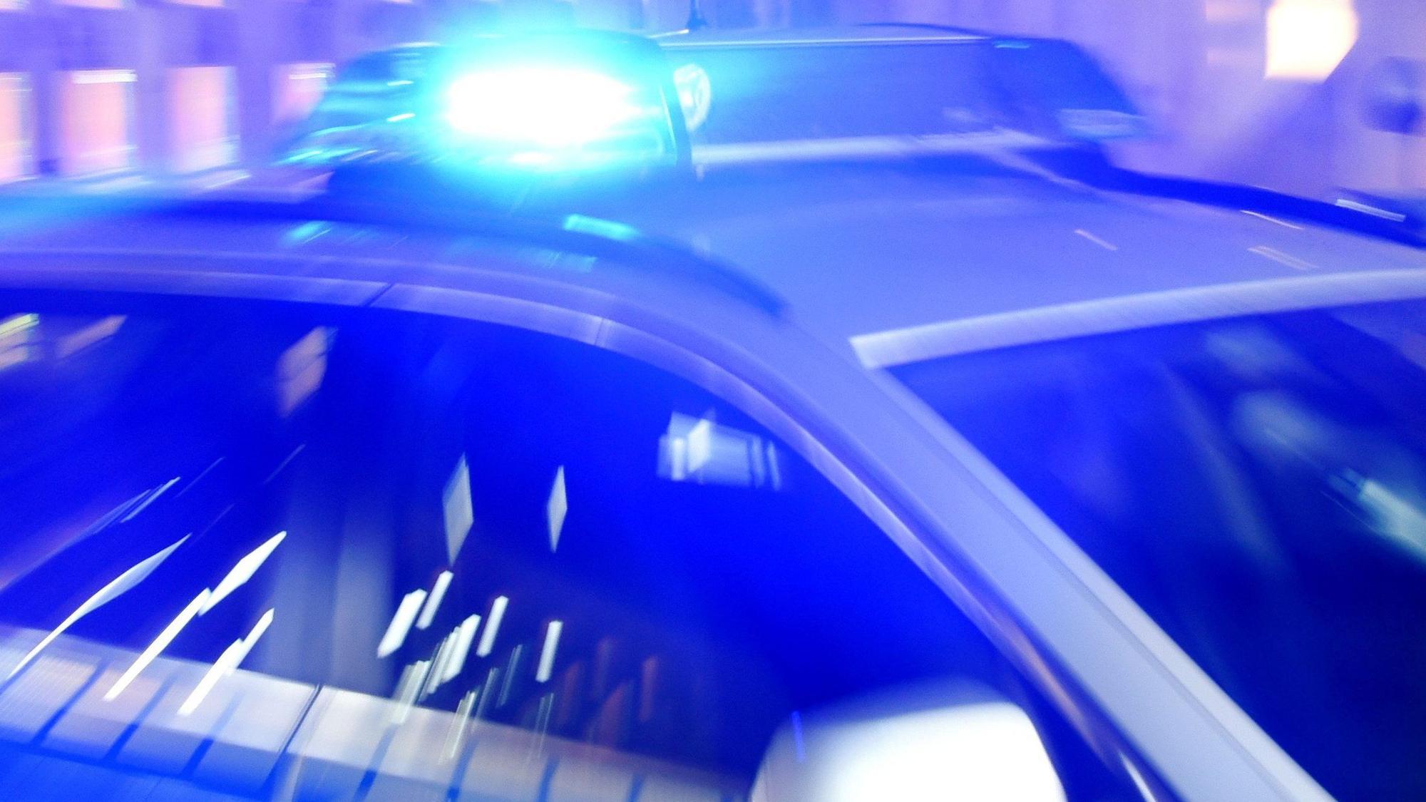 Ein Polizeiwagen mit eingeschaltetem Blaulicht.