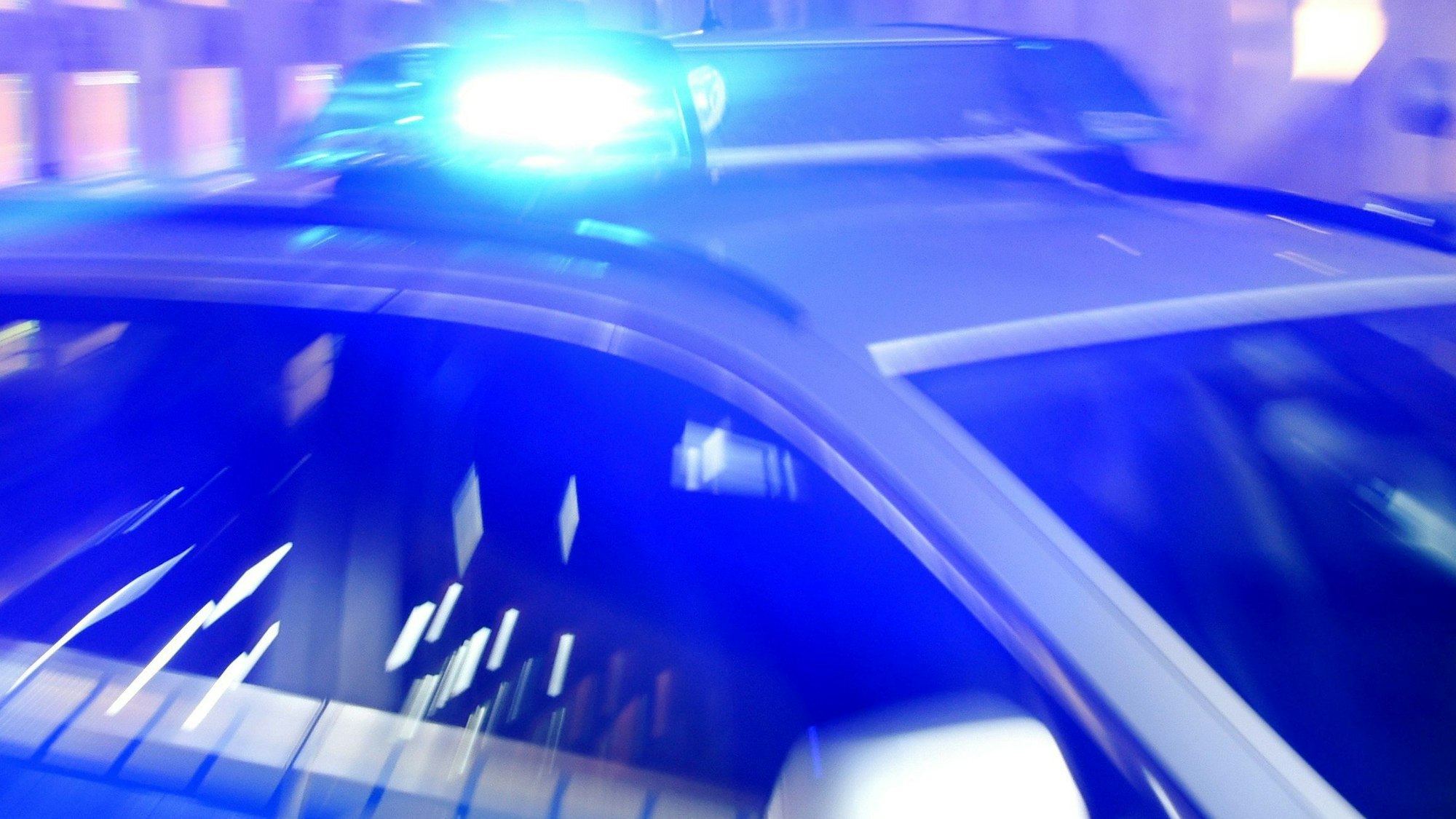 Ein Polizeiwagen mit eingeschaltetem Blaulicht.