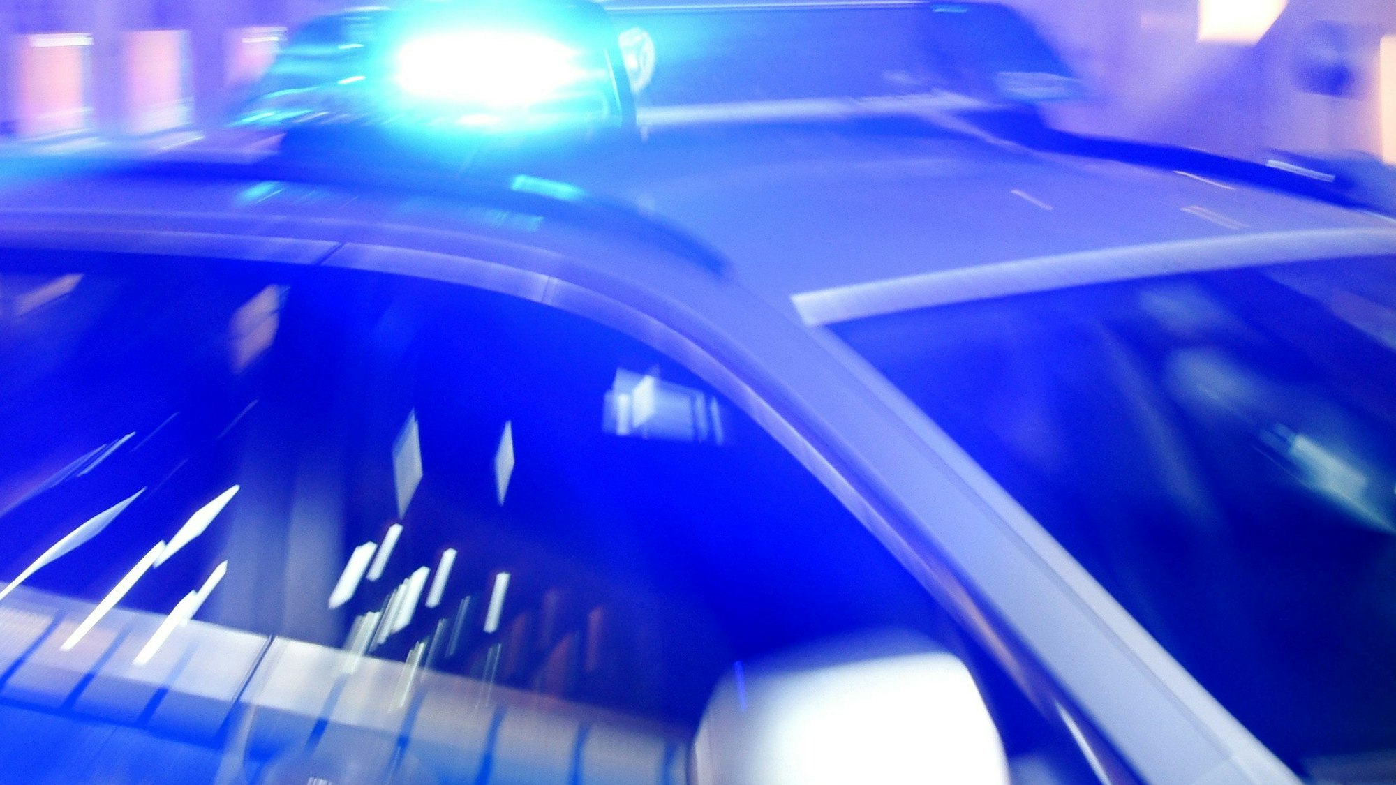Ein Polizeiwagen mit eingeschaltetem Blaulicht.