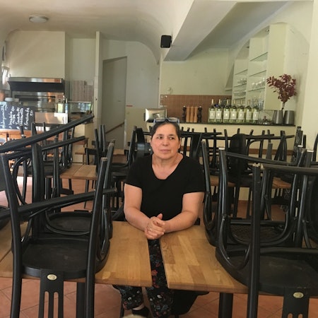 Frau im Lokal zwischen hochgestellten Stühlen