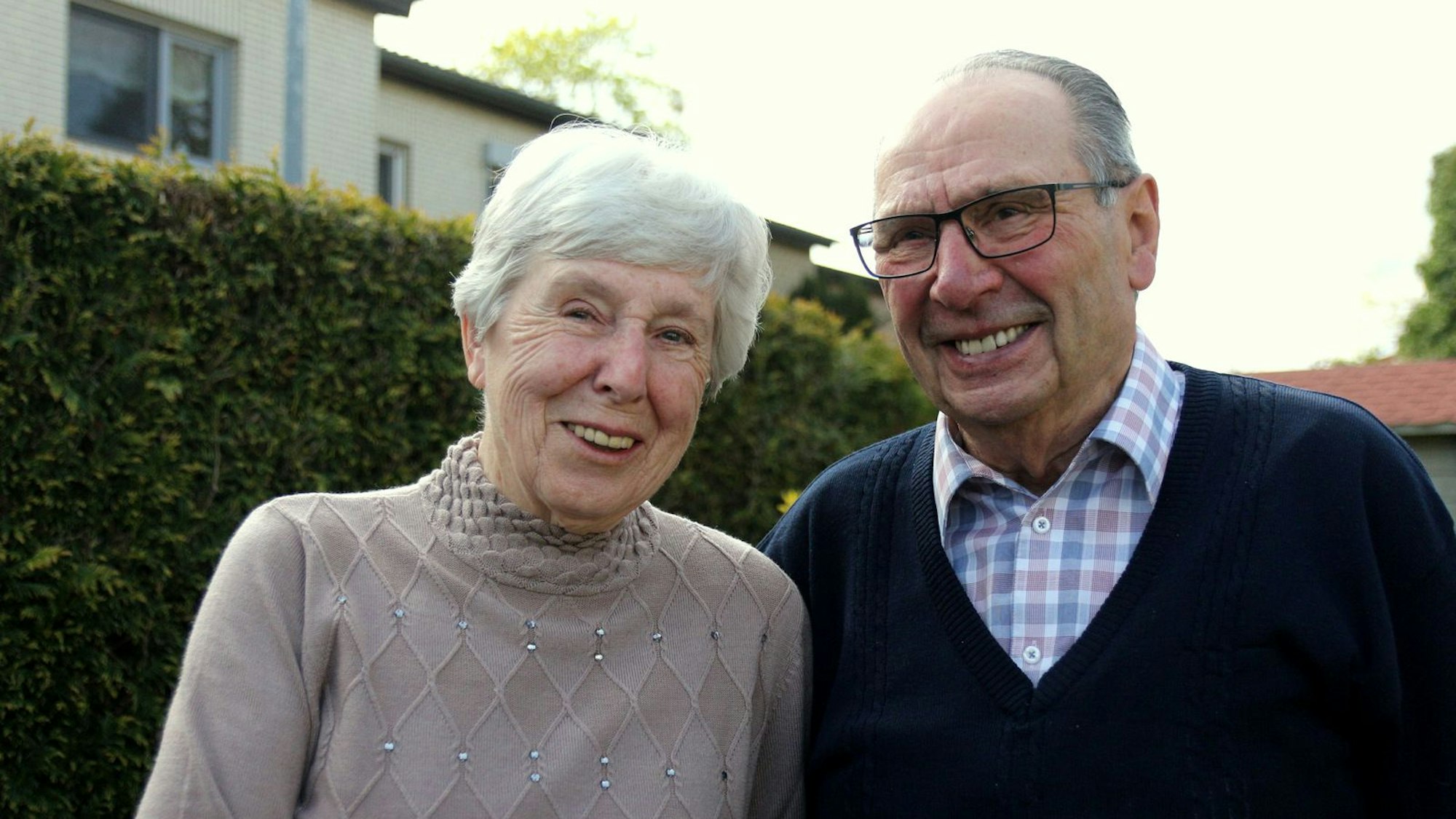 Das Ehepaar blickt lachend in die Kamera.