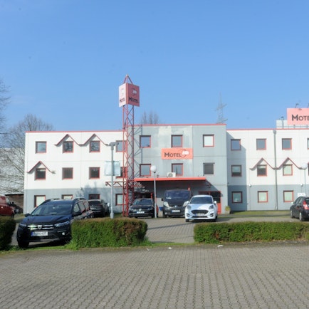 Auf dem Foto ist das Motel 24h an der Europaallee in Frechen zu sehen. Einige Autos sind davor geparkt.