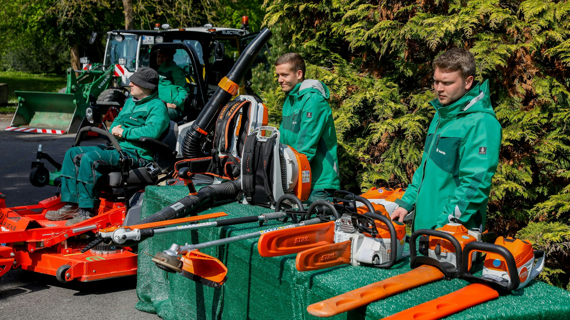 Mitarbeiter der städtischen Grünpflege stellen ihre elektrischen Geräte vor.