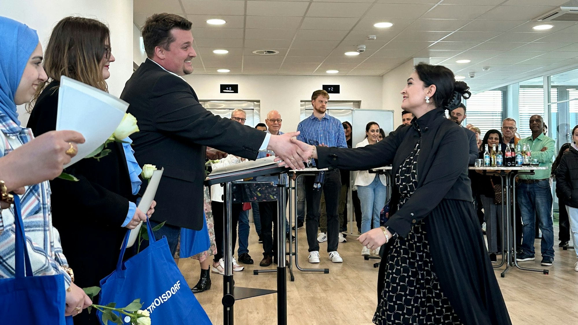 Fatemeh Ranjbar geht dem Bürgermeister entgegen und sie schütteln sich die Hände.