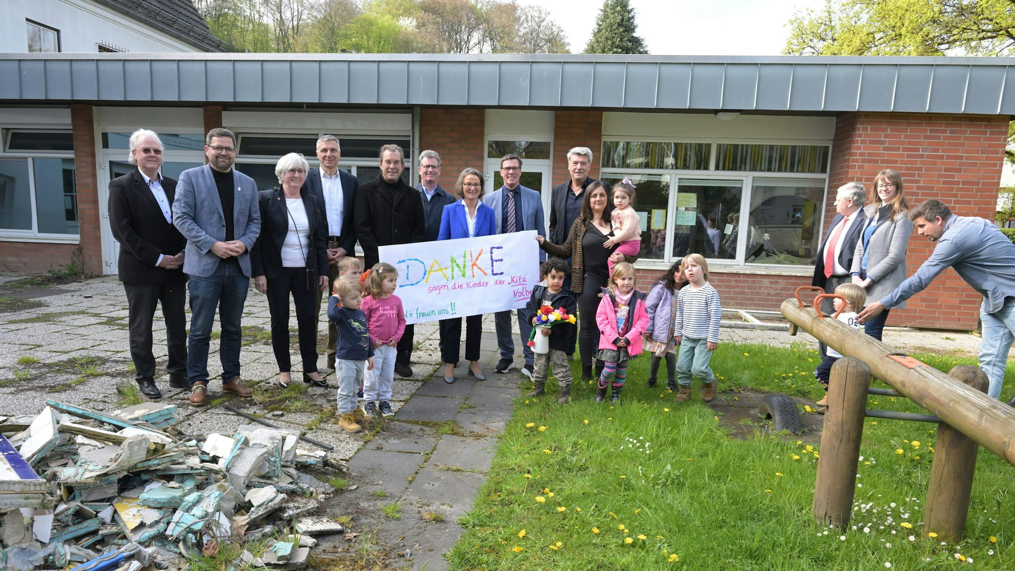 Vor der von der Flut zerstörten Kita Volberg freuten sich alle Beteiligten über das Geld für einen Neubau: Vertreterinnen und Vertreter der Evangelischen Kirche und der Kommunalpolitik, die Planer, die Kinder und Ministerin Ina Scharrenbach (4. v. r., blaues Jackett).