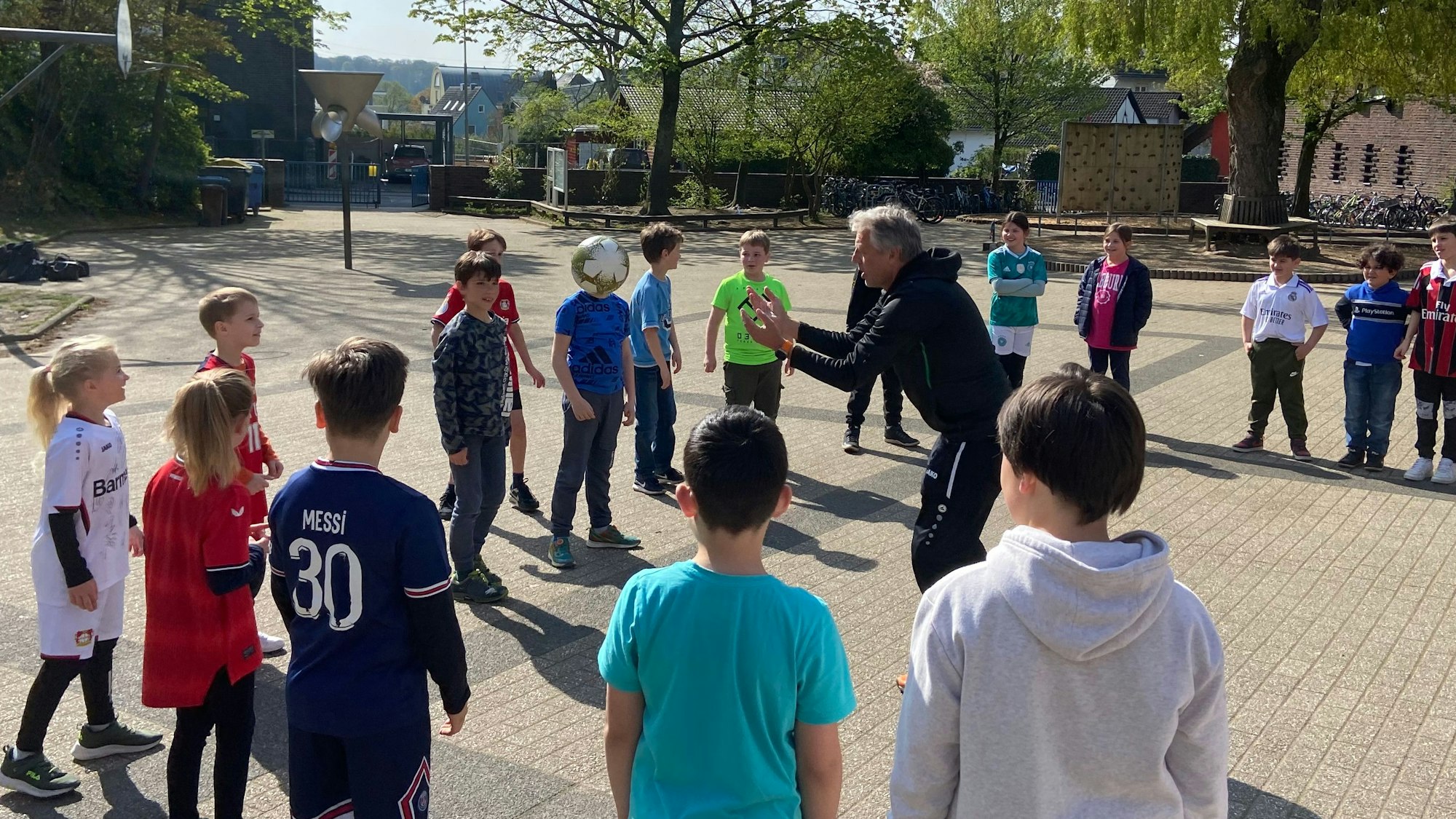 Kinder stehen im Halbkreis um Übungsleiter