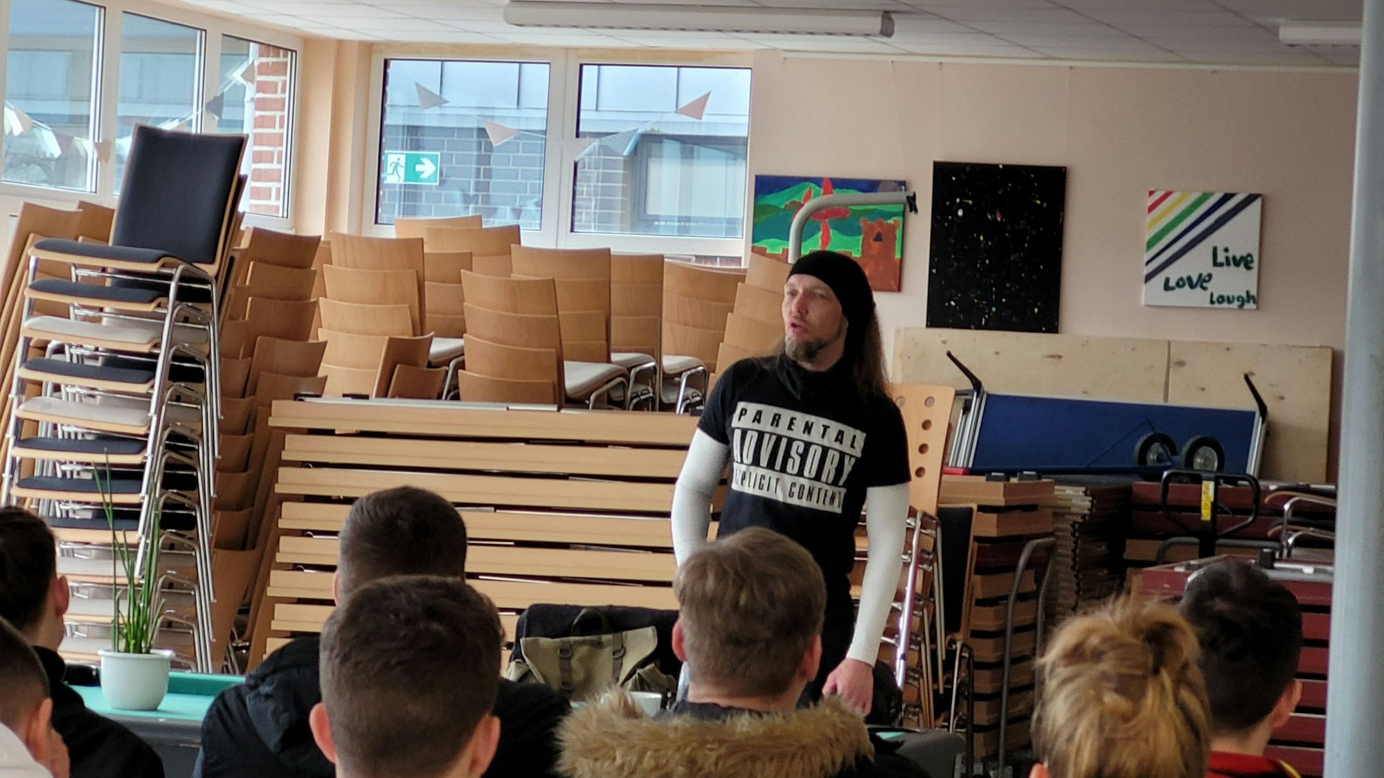 Timo Schüsseler steht vor den sitzenden Schülern und trägt vor.