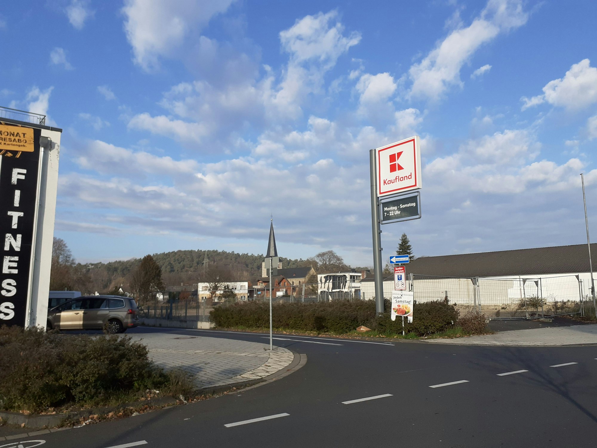 An einer Einmündung steht ein Bauzaun, ein Schild weist auf einen Kaufland-Markt hin.