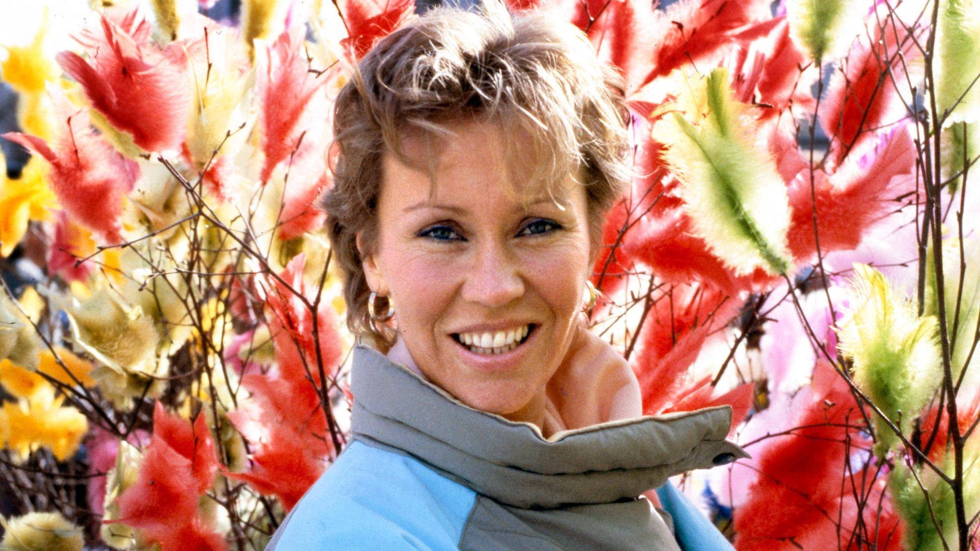 Agnetha Fältskog im Jahre 1985. Sie steht vor bunten Federn.