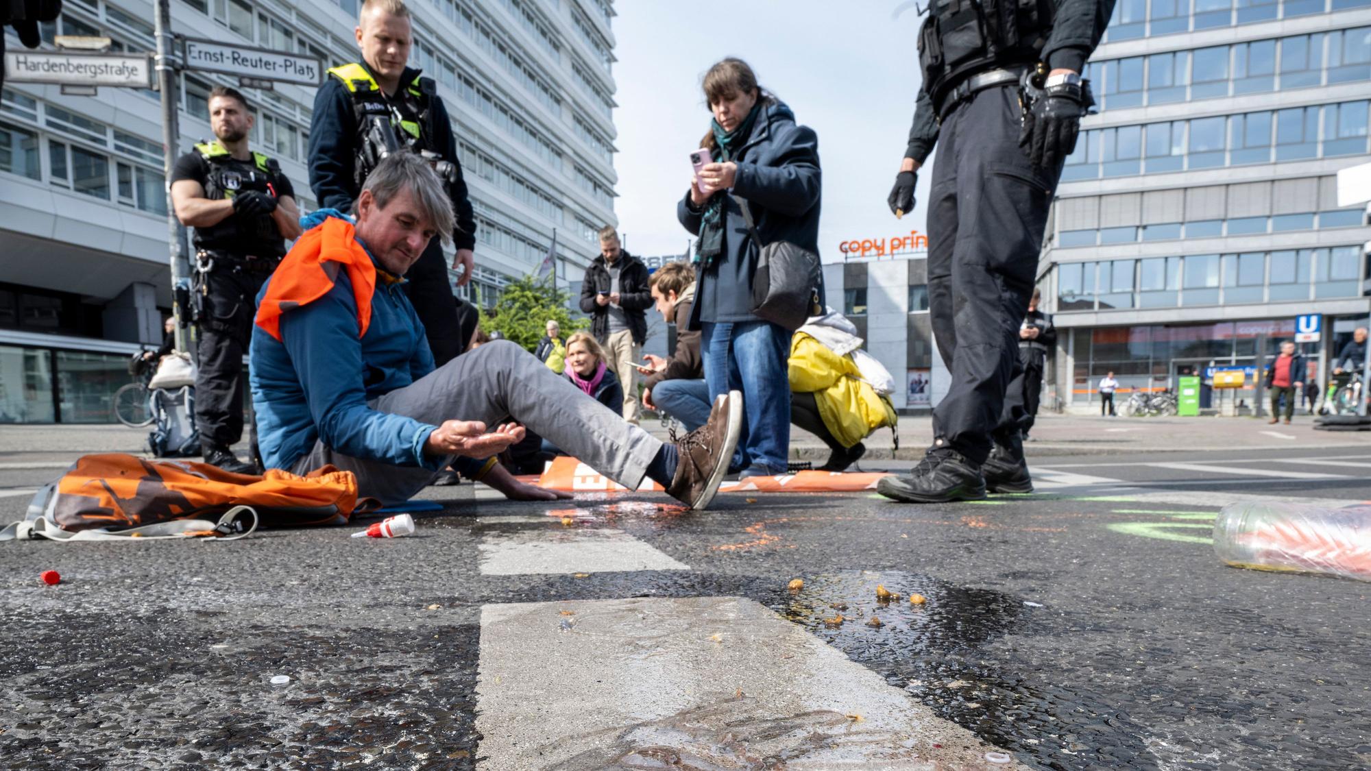 Klebe-Protest: Polizeibeamte entfernen Aktivistinnen und Aktivisten von einer Straße in Berlin.
