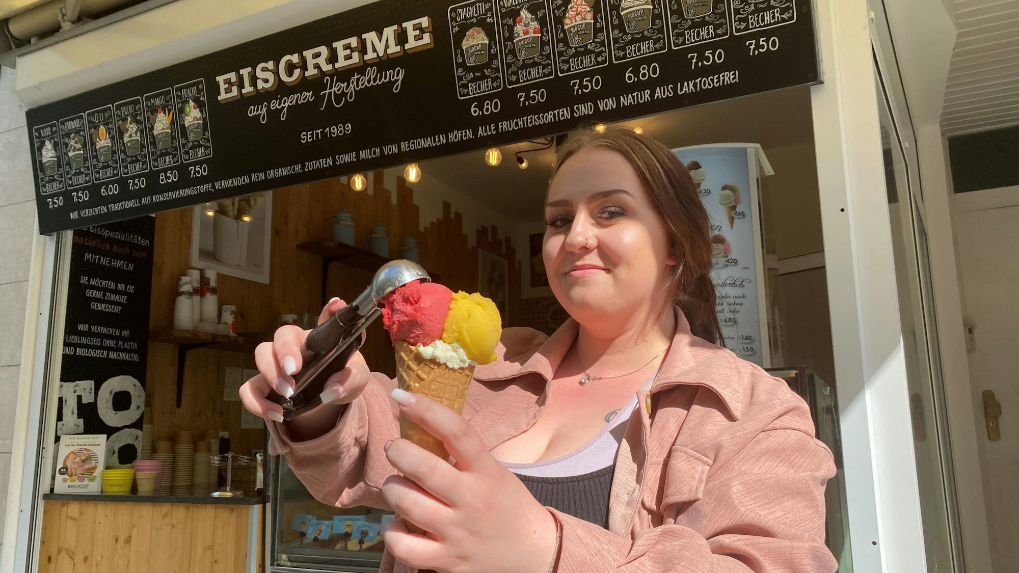 Eine Frau setzt eine Kugel auf eine Eistüte