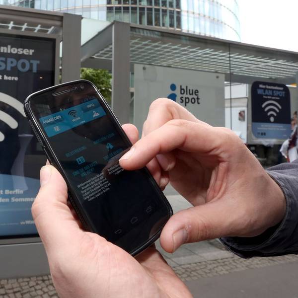 Handynutzer wählt sich an einer Haltestelle in Berlin ins Wlan-Netz ein.